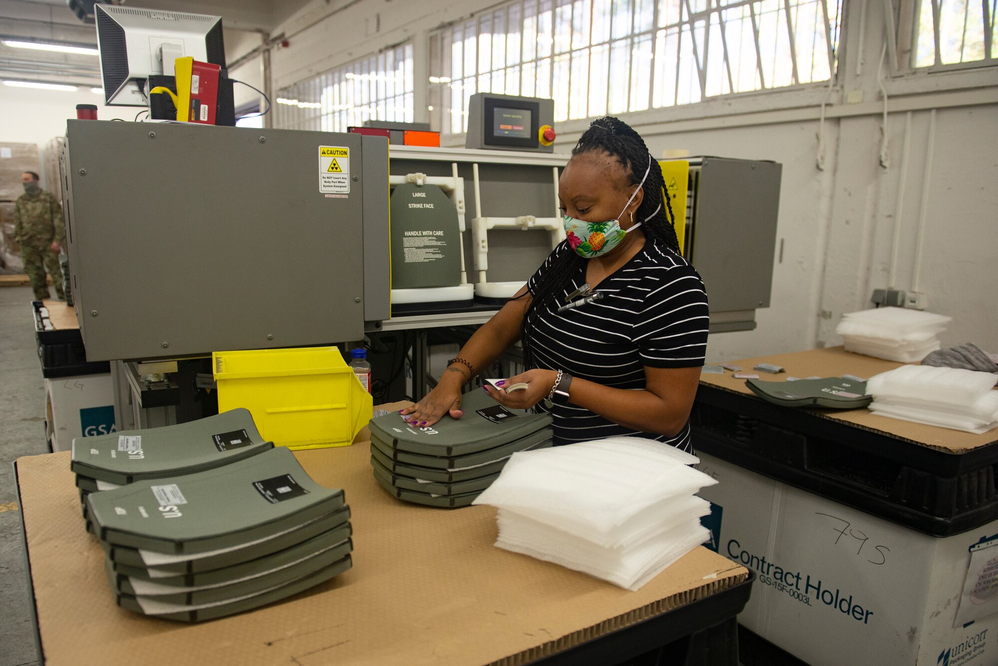 Jazman Brooke, Department of Defense contractor, marks a ballistic vest plate that has passed inspection at Ramstein Air Base, Germany, Oct. 29, 2020