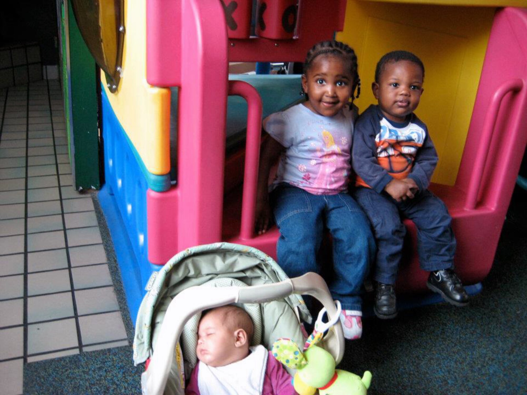 Lenny, age 1; Nya, age 3, and baby Kimmie, at age 3-months, play together during their first visit together after being separated, near Eglin Air Force Base, Florida. Initially, the siblings were placed in separate foster homes in different towns. Social workers facilitated monthly visits. (Courtesy photo)