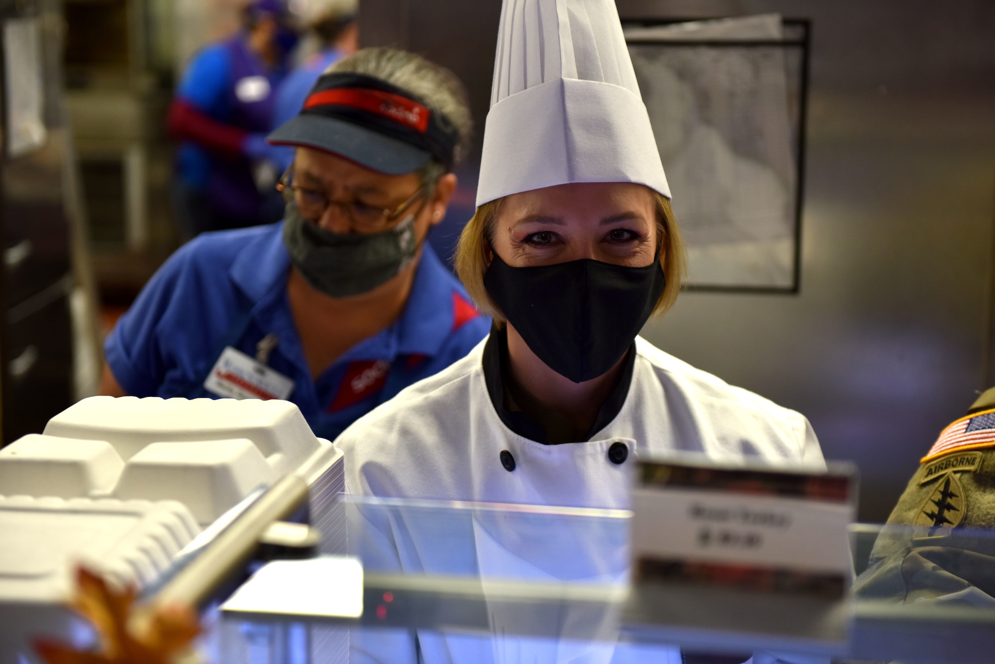 U.S. Air Force Chief Master Sgt. Casy Boomershine, 17th Training Wing command chief, offers turkey to members on the serving line during the Thanksgiving meal at the Western Winds Dining Facility on Goodfellow Air Force Base, Texas, Nov. 26, 2020. This tradition is to ensure those who are away from their families still feel a part of a family here. (U.S. Air Force photo by Staff Sgt. Seraiah Wolf)