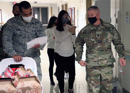 Army Command Sgt. Maj. Thurman Reynolds (right), Brooke Army Medical Center Command Sergeant Major, and Air Force Senior Airman Kevin Nunez (left), look over the list of inpatients receiving Thanksgiving Day baskets Nov. 26.