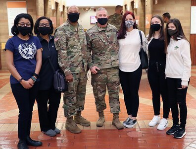 Army Brig. Gen. Shan K Bagby, Brooke Army Medical Center commanding general, wife Melanie, and daughter Sydney (far left), and Army Command Sgt. Maj. Thurman Reynolds and his wife Tommi, and daughters Teigen and Alexis (far right), prepare to deliver Thanksgiving baskets to inpatients Nov. 26.