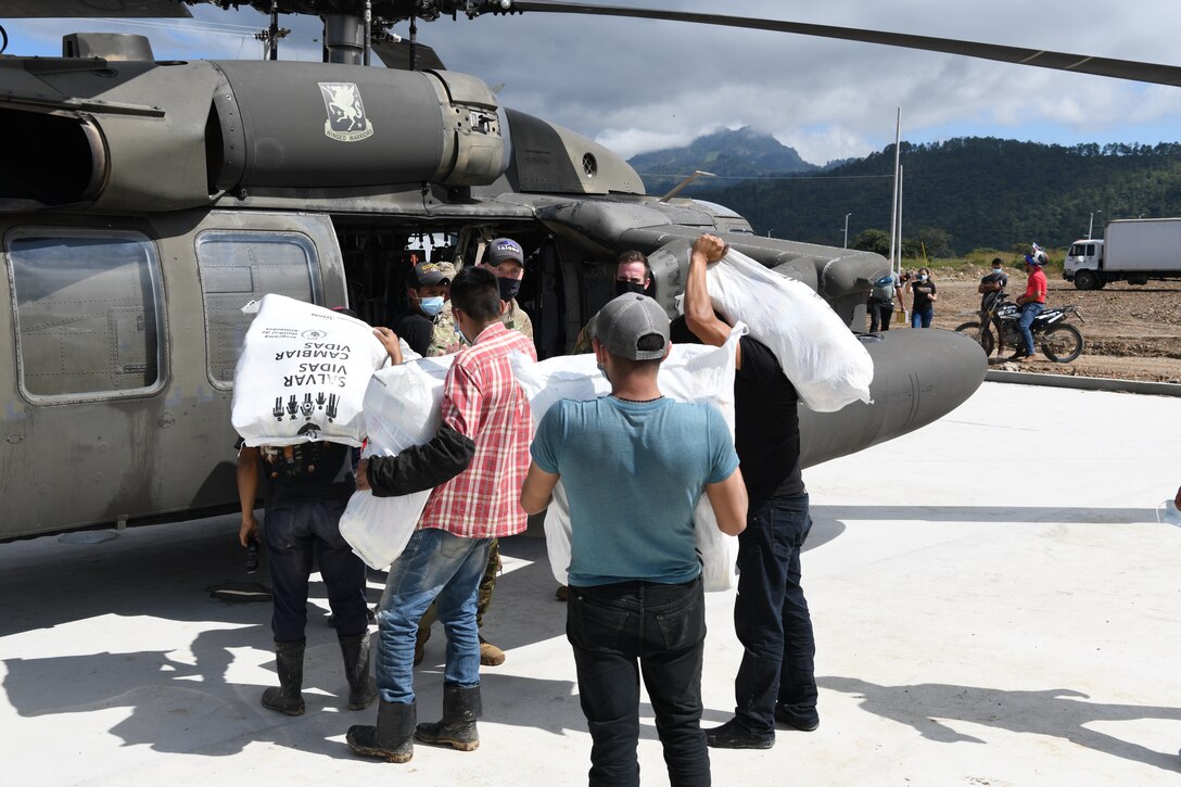 U.S. Army Soldiers and Honduran volunteers load humanitarian aid on to a UH-60 Black Hawk helicopter at a coffee processing facility in Belen Gualcho, Ocotepeque, Honduras.