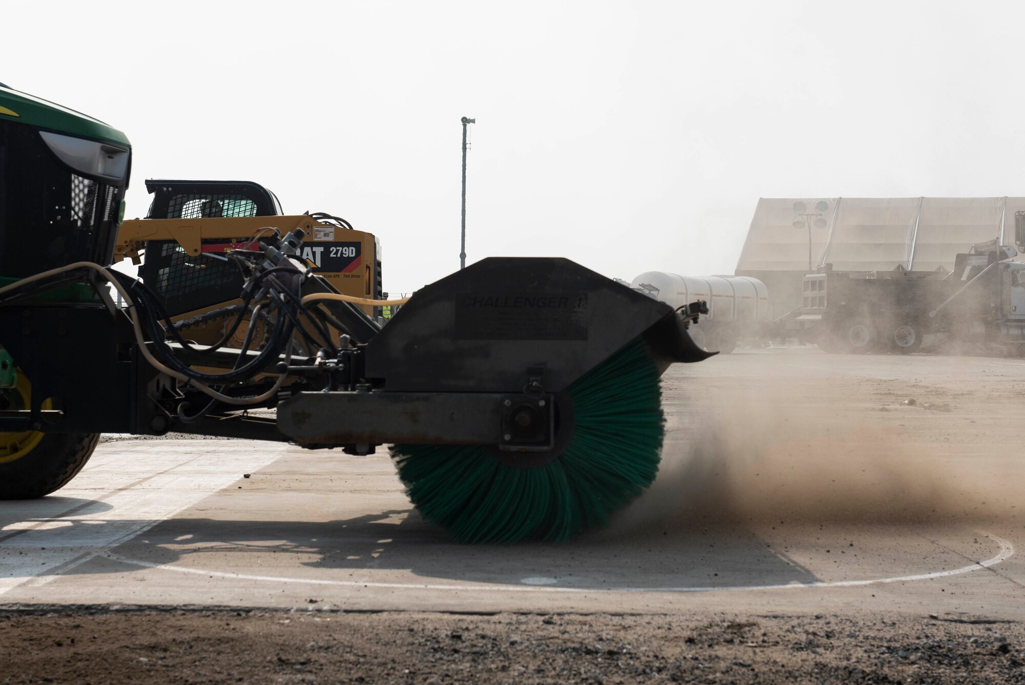 A tractor with a sweeper attachment removes debris during a Rapid Airfield Damage Recovery training exercise at Ali Al Salem Air Base, Kuwait, Nov. 16, 2020. Once the debris is removed and the concrete dries, the repaired airfield would be operational again. (U.S. Air Force photo by Staff Sgt. Kenneth Boyton)