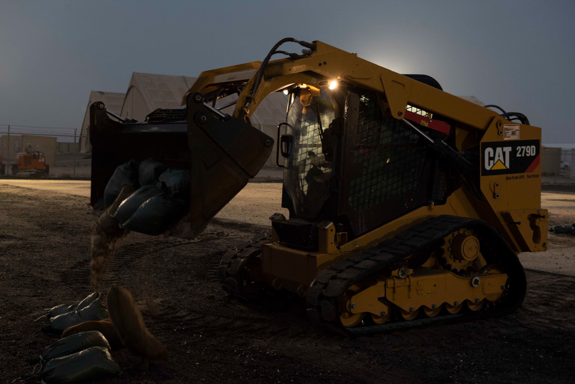 A U.S. Air Force Airman from the 386th Expeditionary Civil Engineer Squadron removes debris with a compact track loader during a Rapid Airfield Damage Recovery training exercise at Ali Al Salem Air Base, Kuwait, Nov. 16, 2020. The intent of RADR training is for Airmen from different ECES shops to work together simultaneously to expeditiously repair a damaged runway. (U.S. Air Force photo by Staff Sgt. Kenneth Boyton)