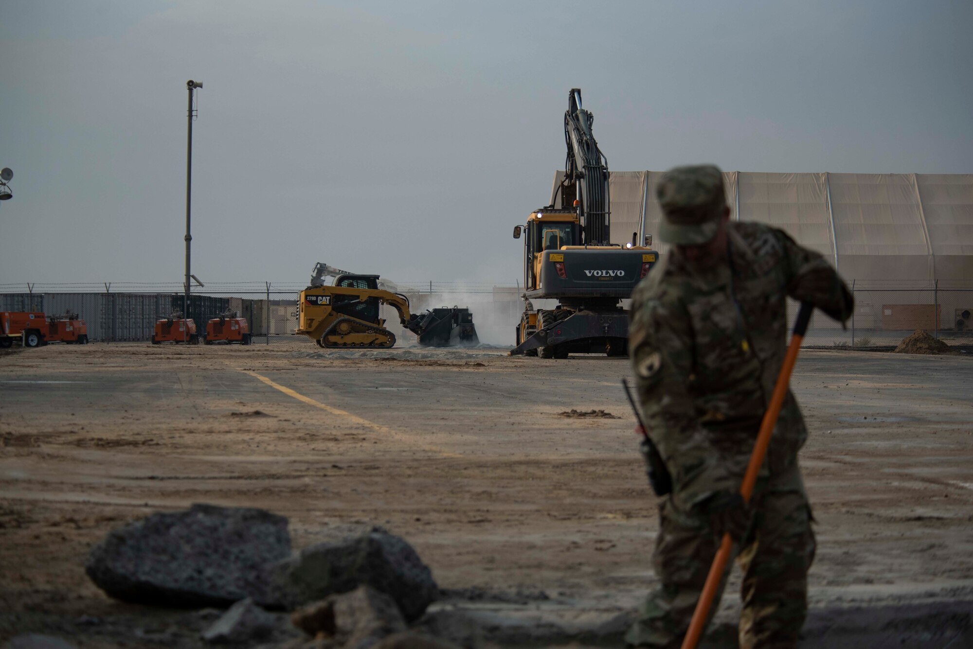 A U.S. Air Force Airman from the 386th Expeditionary Civil Engineer Squadron removes debris from a crater during a Rapid Airfield Damage Recovery training exercise at Ali Al Salem Air Base, Kuwait, Nov. 16, 2020. The RADR process utilizes different teams to do specific tasks, efficiently repairing a damaged runway in a short amount of time. (U.S. Air Force photo by Staff Sgt. Kenneth Boyton)