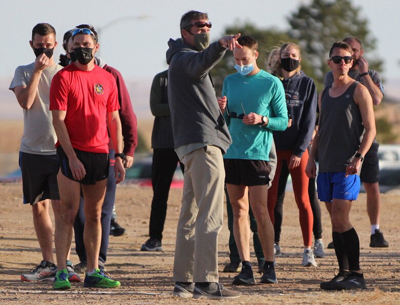 Seth Cannello, 50th Force Support Squadron fitness center director, shows runners where to go for the 19th annual Turkey Trot race Nov. 20, 2020, at Schriever Air Force Base, Colorado. The race followed the “wing run” route, which begins north of the batting cages and continues west on the running trail, then north along the perimeter fence line. The route then wraps along the housing area and back to the start. (U.S. Space Force photo by Marcus Hill)