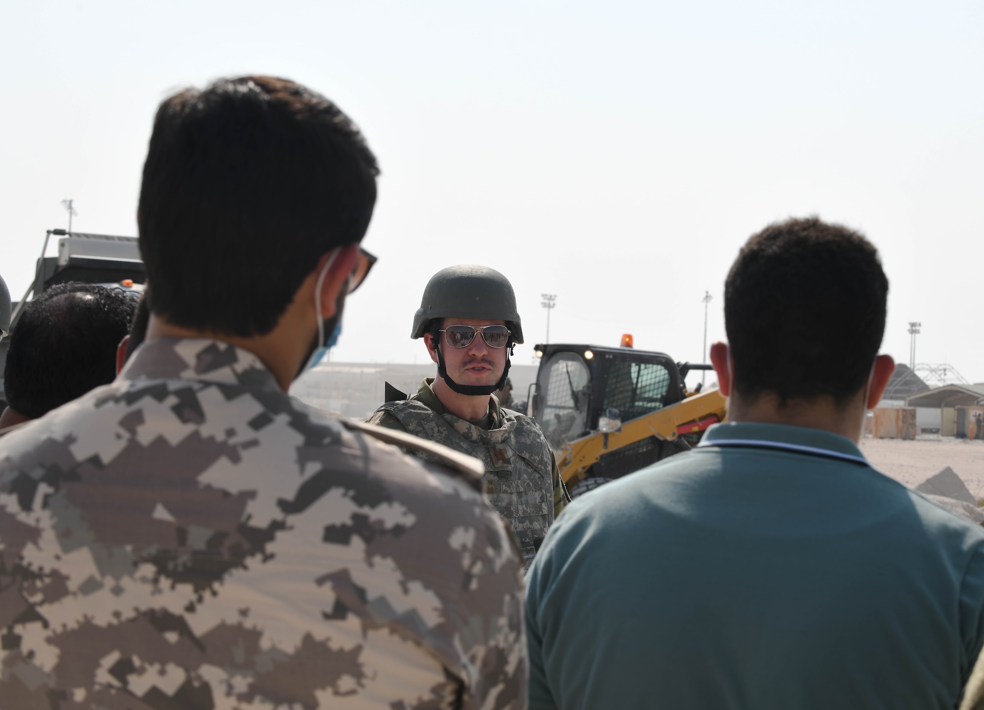 U.S. Air Force Capt. Scott Guerin, assigned to the 379th Expeditionary Civil Engineer Squadron, talks to Qatari civilians and military members at Al Udeid Air Base, Qatar, Nov. 18, 2020. Guerin gave the Qatari observers a guided tour as 379th ECES Airmen conducted rapid airfield damage repair training, which challenged them to efficiently and expeditiously restore a damaged airfield to operational status. (U.S. Air Force photo by Staff Sgt. Kayla White)