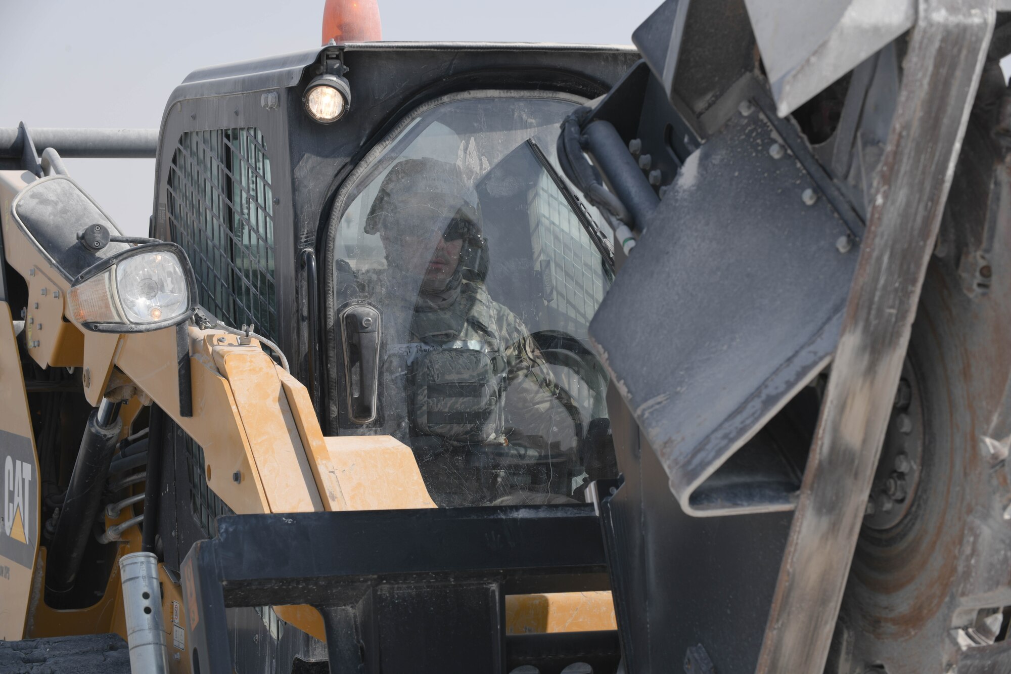 U.S. Air Force Staff Sgt. Douglas Murillo, with the 379th Expeditionary Civil Engineer Squadron, operates a compact track loader during rapid airfield damage repair training at Al Udeid Air Base, Qatar, Nov. 18, 2020. The 379th ECES conducted the training to assure their readiness to efficiently and expeditiously restore a damaged airfield to operational status. (U.S. Air Force photo by Staff Sgt. Kayla White)