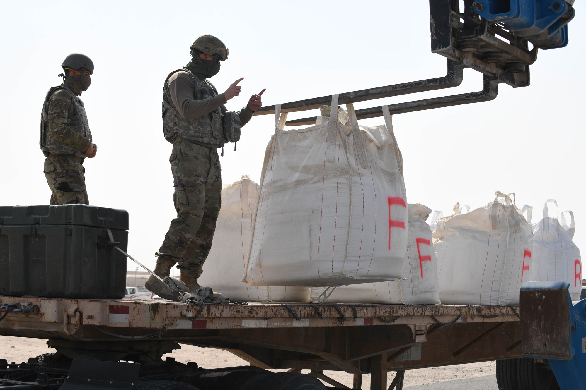 U.S. Airmen assigned to the 379th Expeditionary Civil Engineer Squadron use a telescopic handler to move a large bag of concrete mix during a rapid airfield damage repair exercise at Al Udeid Air Base, Qatar, Nov. 18, 2020. 379th ECES Airmen used the mix to repair craters in a mock airfield after a notional attack. The RADR training prepared the Airmen to efficiently and expeditiously restore a damaged airfield to operational status. (U.S. Air Force photo by Staff Sgt. Kayla White)