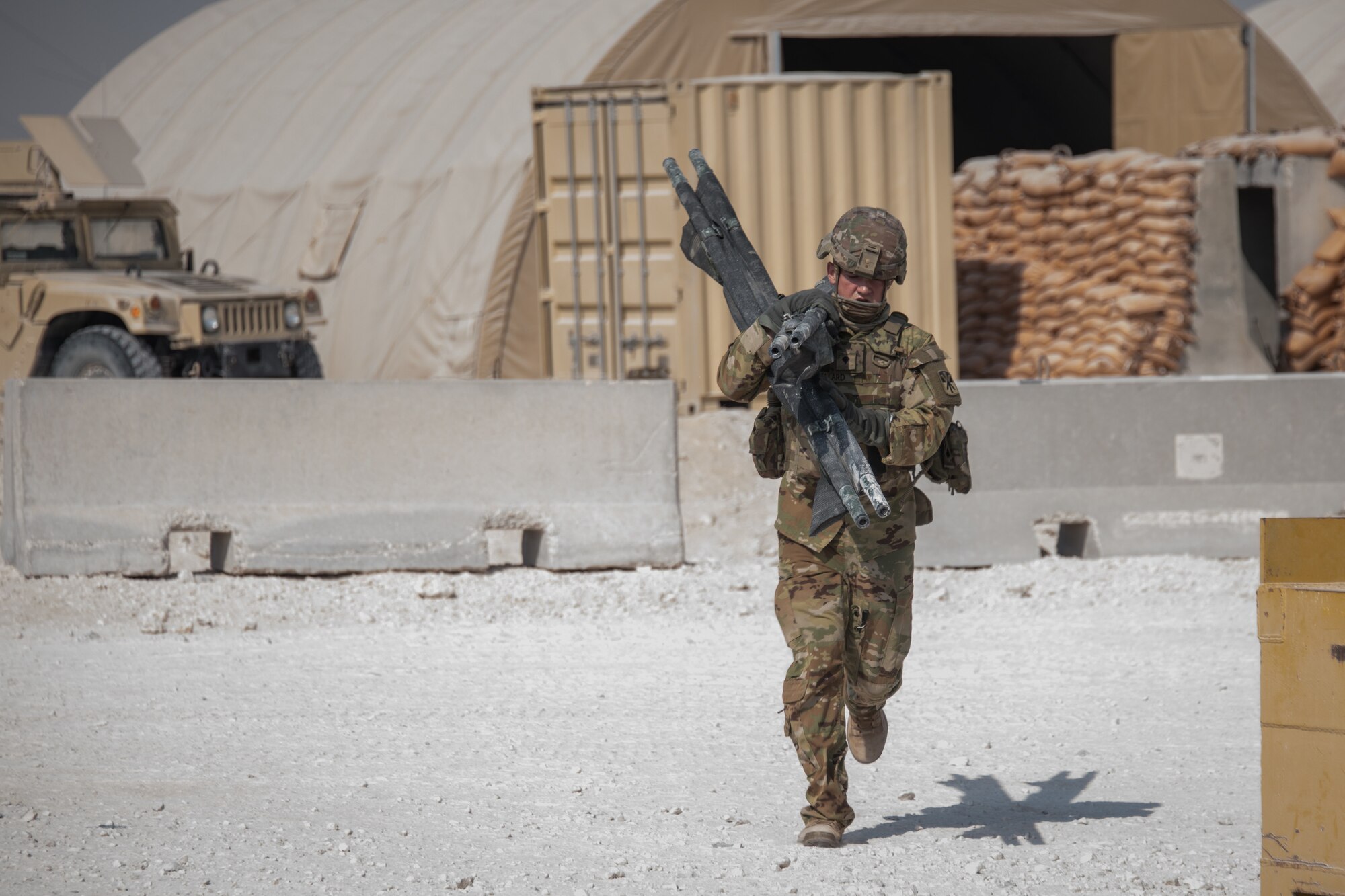 a soldier carries two stretchers that are folded