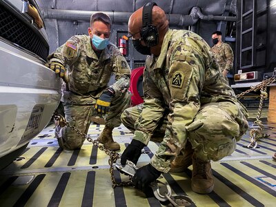 Staff Sgt. Whitfield Leach (right), U.S. Army North’s Task Force 51’s aide-de-camp, tightens down chains attached to an emergency response vehicle as Lt. Col. Jeremy Gottshall (left), U.S. Army North’s Task Force 51’s logistic officer in charge, observes during the unit’s Level II Deployment Readiness Exercise at Joint Base San Antonio-Kelly Field Annex Nov. 20.