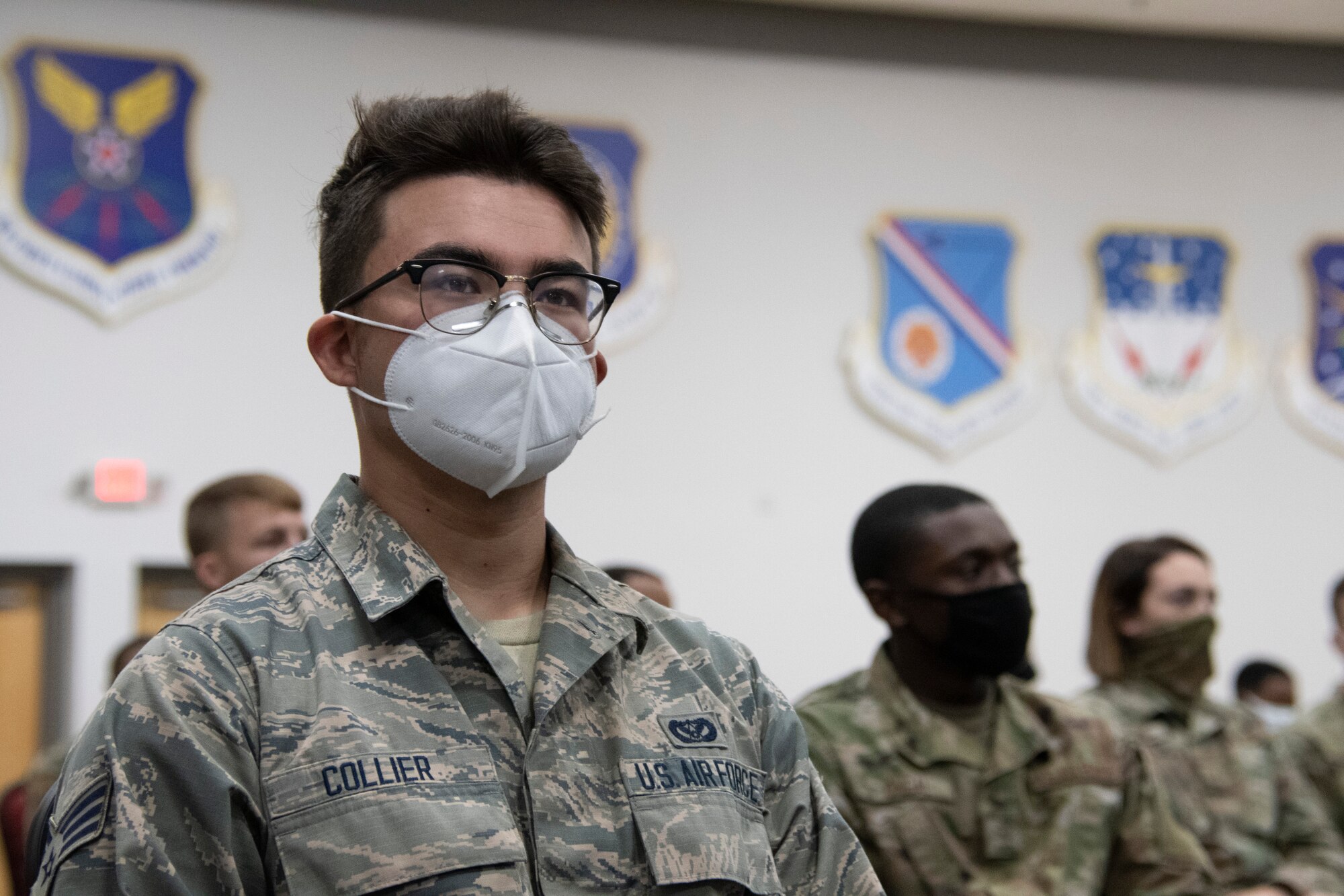 An Airman listens to a talk during a town hall meeting.