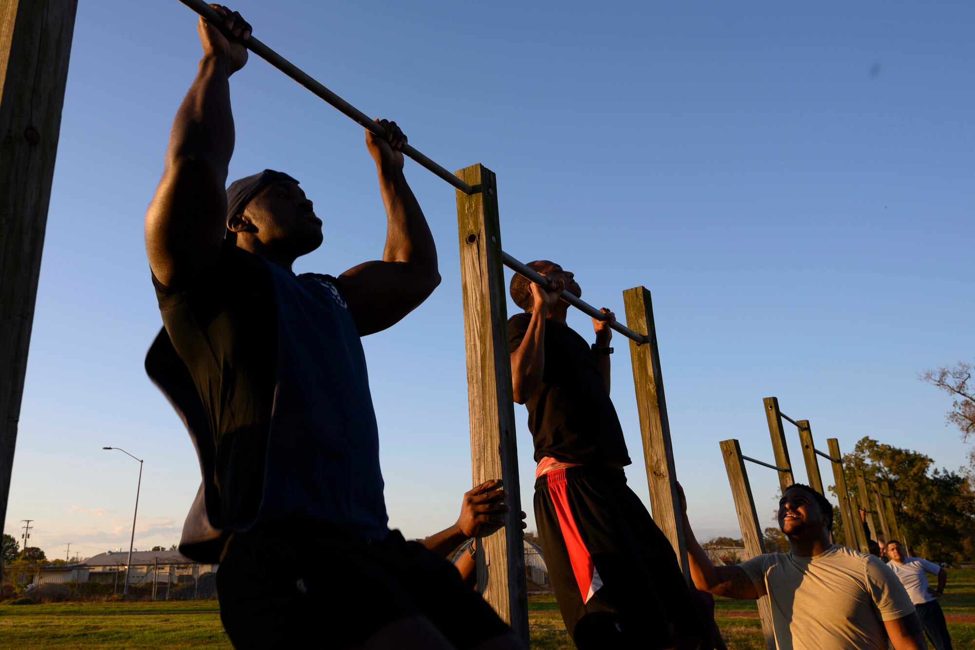 Silhouette of Airmen doing pullups.