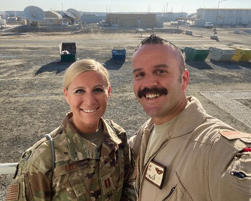 Active duty Air Force woman and man in uniform outside in a desert location.