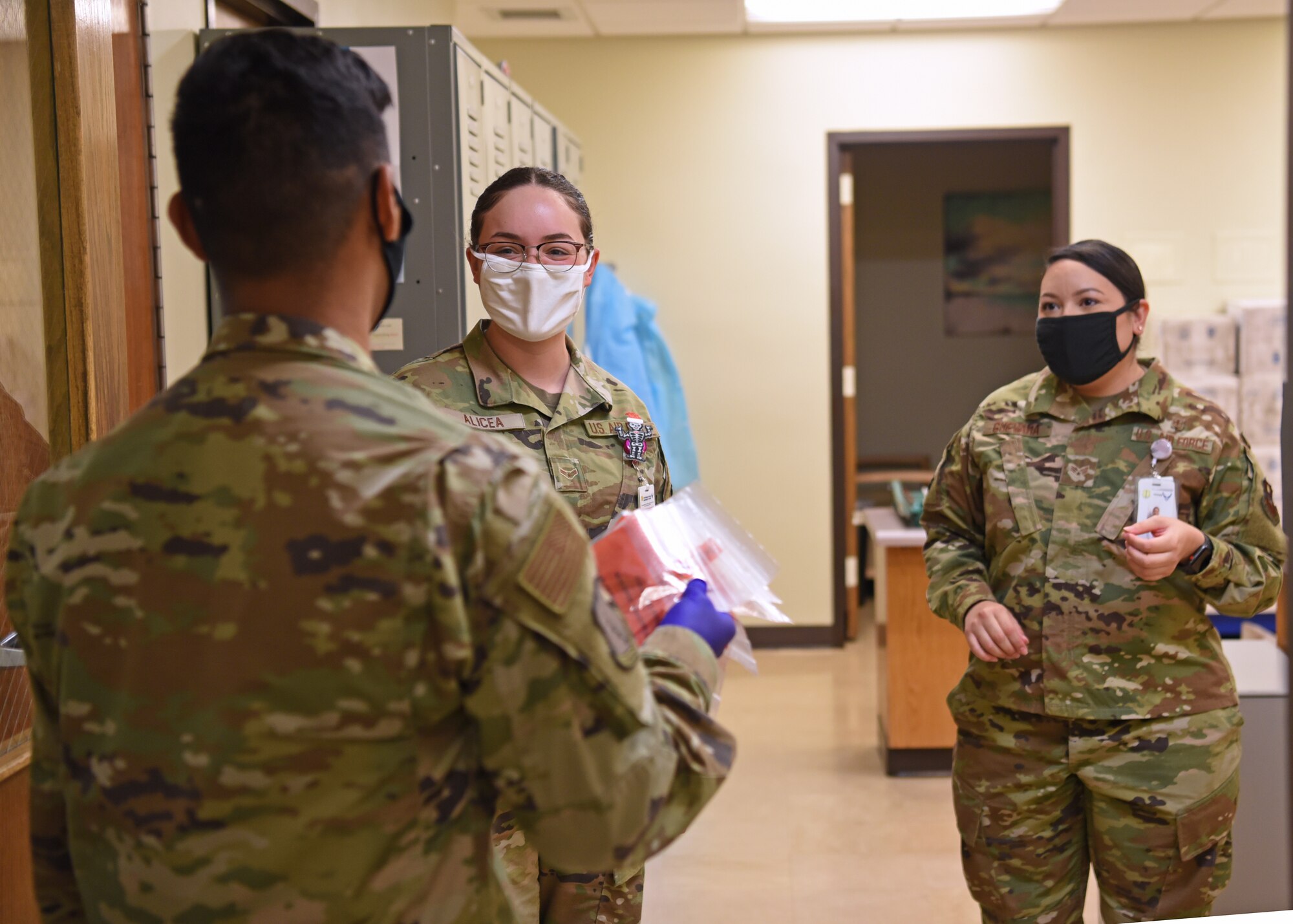 U.S. Air Force Airman Santiago Diaz, 17th Healthcare Operations Squadron, hand delivers eight COVID-19 screening samples to the laboratory for testing at the Ross Clinic on Goodfellow Air Force Base, Texas, Nov. 23, 2020. Wearing gloves, masks and allowing a physical distance between coworkers became the new normal.  (U.S. Air Force photo by Senior Airman Abbey Rieves)