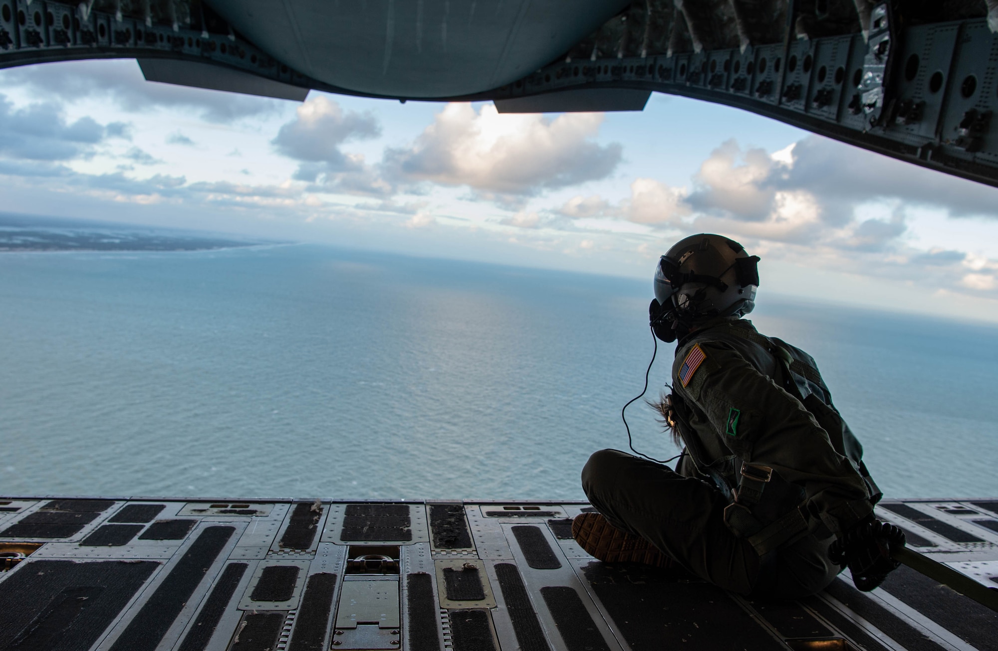 Staff Sgt. Elizabeth Finley, C-17 West Coast Demo Team loadmaster and 4th Airlift Squadron evaluator loadmaster, sits on the ramp of a C-17 Globemaster III flying along the coast near Fort Lauderdale, Fla., Nov. 19, 2020. Finley and the other West Coast Demo Team Airmen participated in the 2020 Fort Lauderdale Air Show, Nov. 21-22. (U.S. Air Force photo by Senior Airman Tryphena Mayhugh)