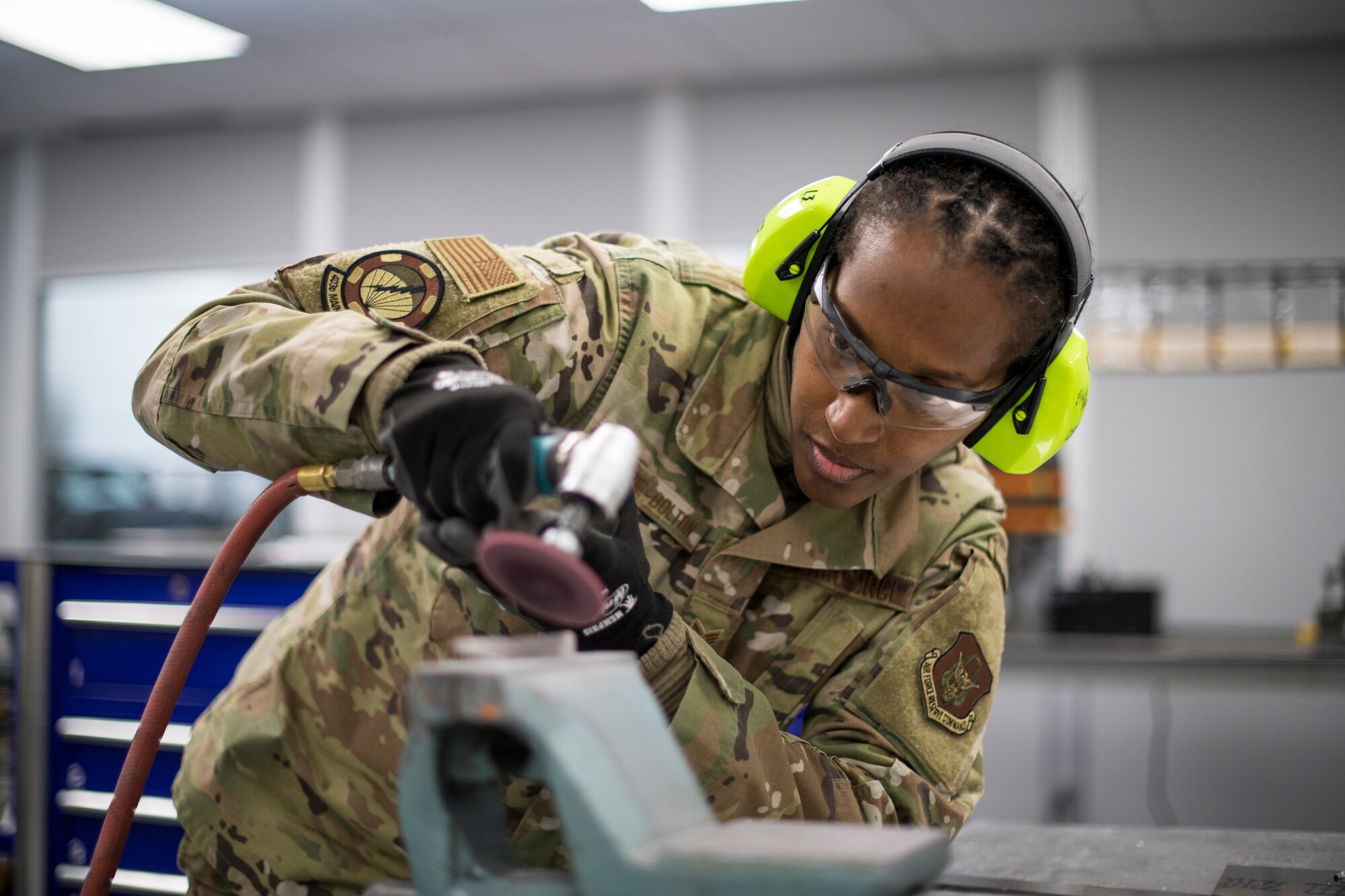 Senior Airman Ebony McKenzie-Bolton, 403rd Fabrication Flight metals technology apprentice, grinds a piece of aluminum Nov. 30, 2020 at Keesler Air Force Base, Mississippi. The  Fabrication Flight is responsible for aircraft structural maintenance to include painting and sanding of aircraft parts. The 403rd Wing’s fleet consists of 10 WC-130J and 10 C-130J Super Hercules aircraft which are flown by the 53rd Weather Reconnaissance Squadron and 815th Airlift Squadron, respectively. (U.S. Air Force photo by 2nd Lt. Christopher Carranza)