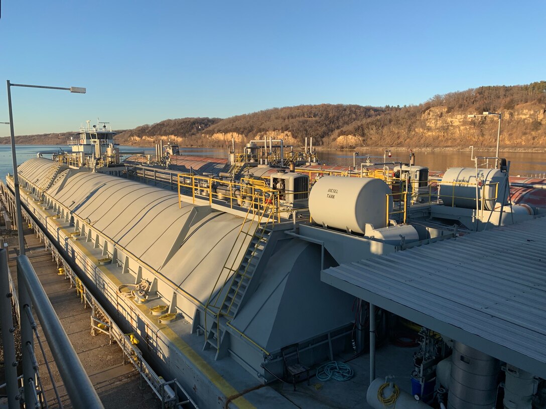 A towboat pushes two barges through a loch chamber.