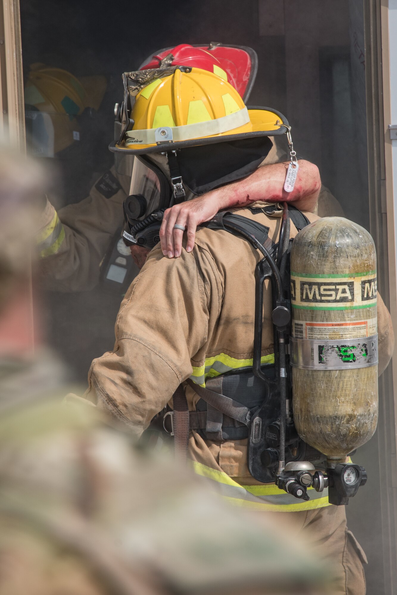 firefighter carries an injured patient