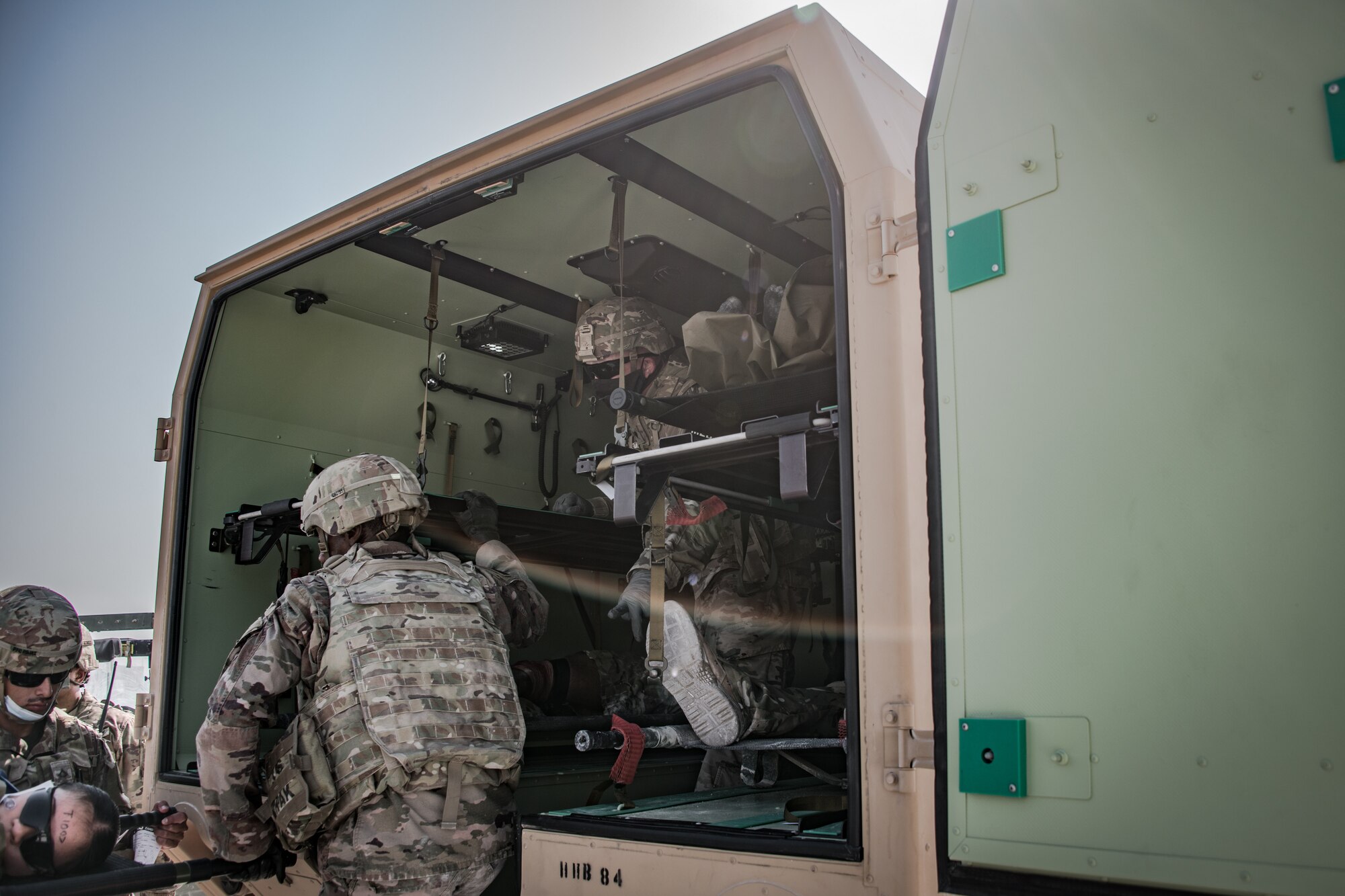 U.S. soldiers lift a litter into an emergency transport vehicle
