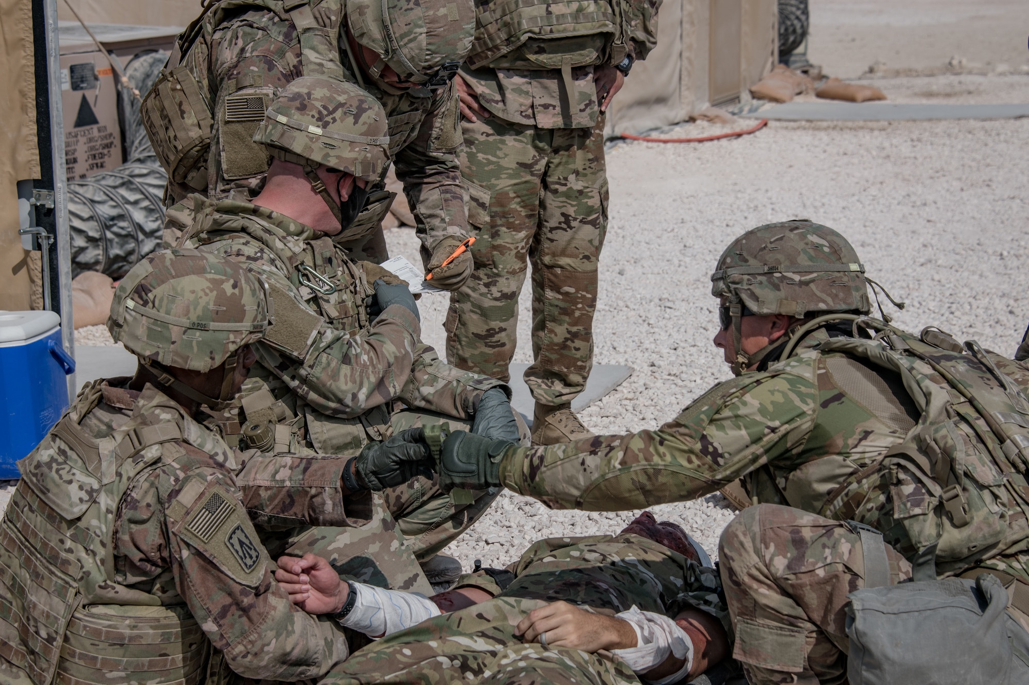 U.S. soldiers wrap gauze around a simulated patient