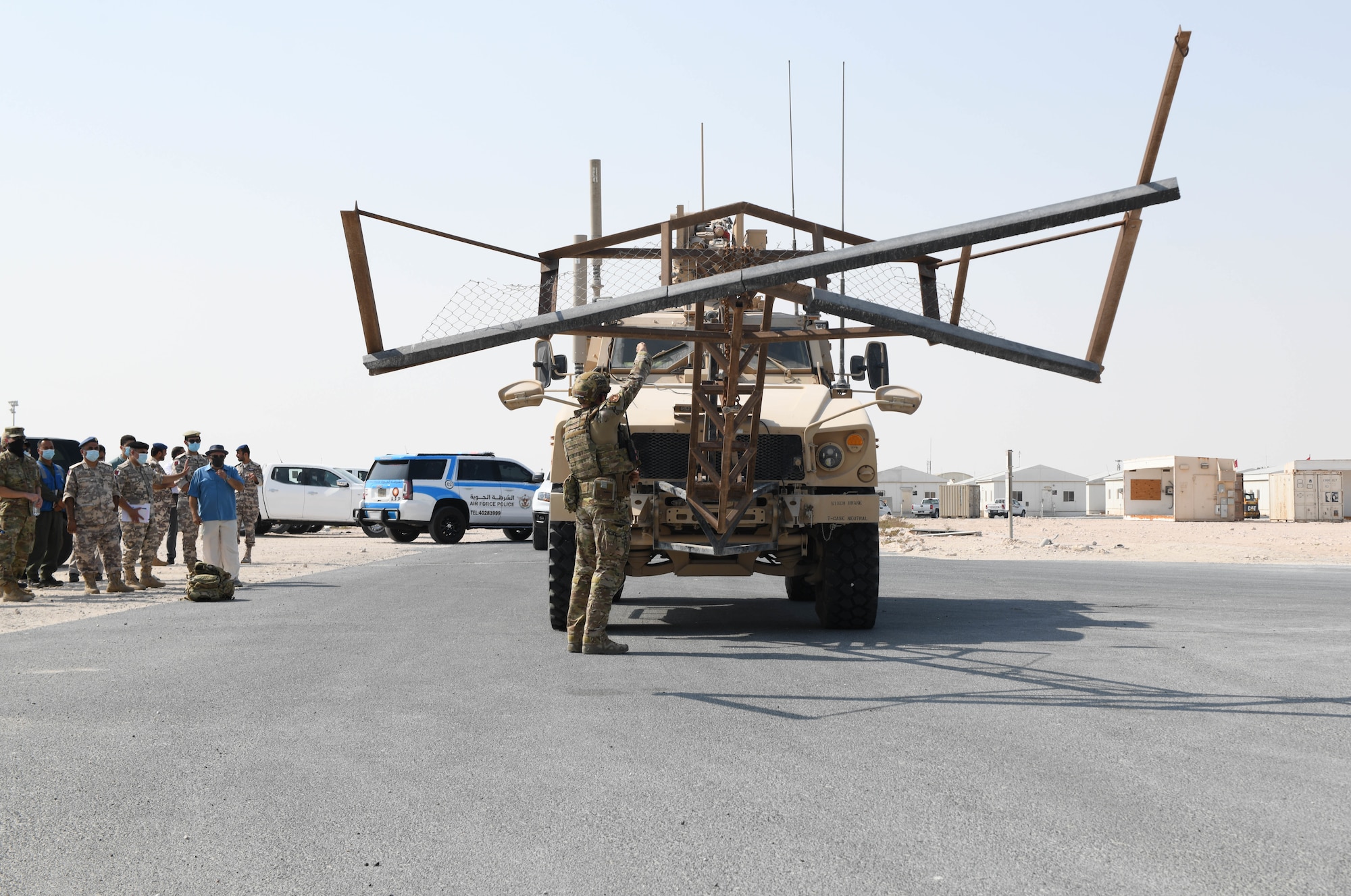 U.S. Air Force Master Sgt. Charles Schewmaker, 379th Expeditionary Civil Engineer Squadron explosive ordnance disposal branch, makes adjustments to an attachment on the front of a mine-resistant ambush-protected all-terrain vehicle at Al Udeid Air Base, Qatar, Nov. 18, 2020. Schewmaker and other EOD members used the M-ATV to clear simulated unexploded ordnance from a training field before engineers came through during the next phase of rapid airfield damage repair training. RADR training prepares ECES Airmen to make expeditious repairs to an airfield after it has been damaged in an attack. (U.S. Air Force photo by Staff Sgt. Kayla White)