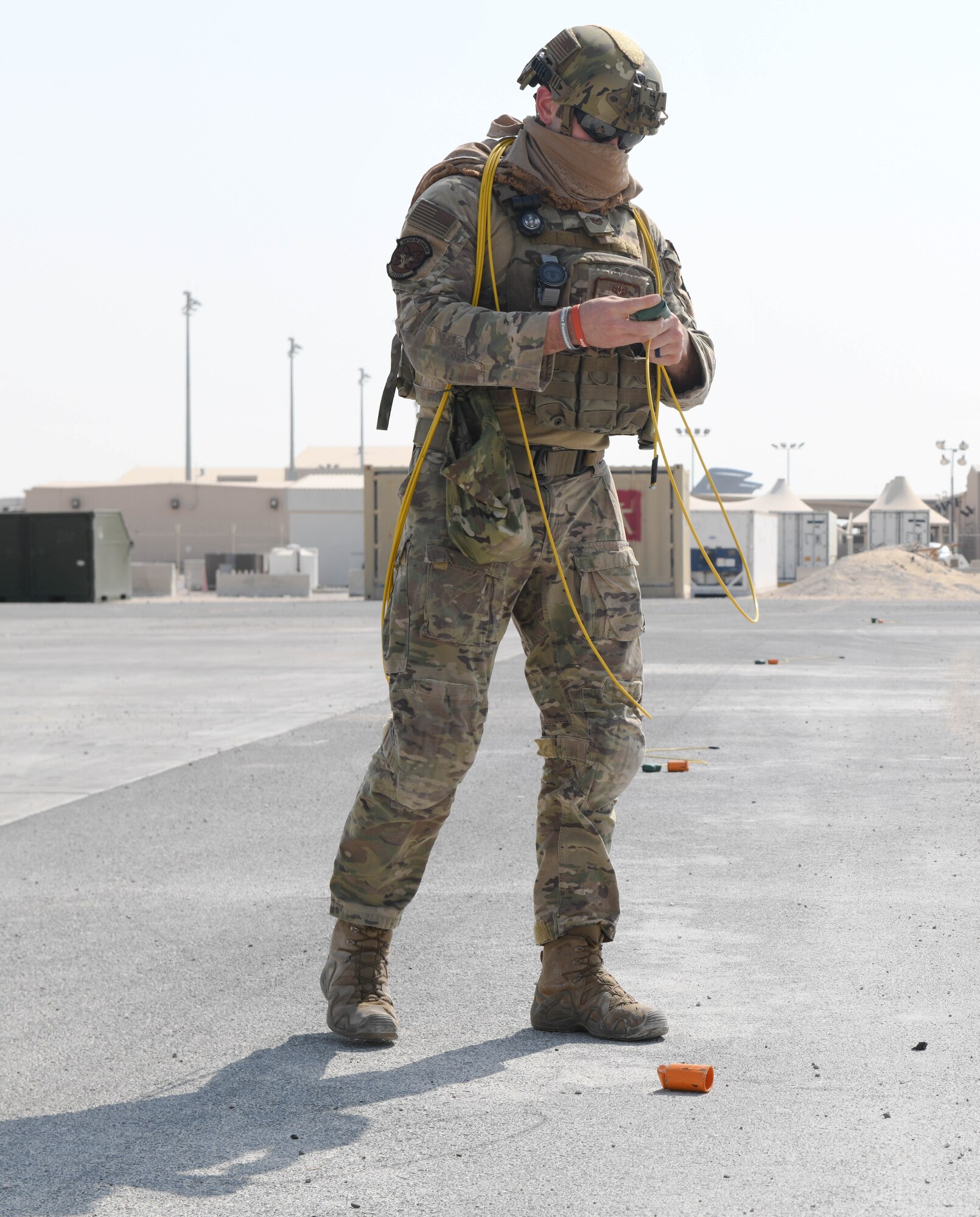 U.S. Air Force Tech. Sgt. Sherwood Johnson IV, 379th Expeditionary Civil Engineer Squadron explosive ordnance disposal branch, prepares a mock explosive while sweeping a training field to clear simulated unexploded ordnance during rapid airfield damage repair training at Al Udeid Air Base, Qatar, Nov. 18, 2020. Johnson and his EOD wingmen participated in the RADR exercise, which prepared 379th ECES to make expeditious repairs to an airfield after it has sustained damage during an attack. (U.S. Air Force photo by Staff Sgt. Kayla White)