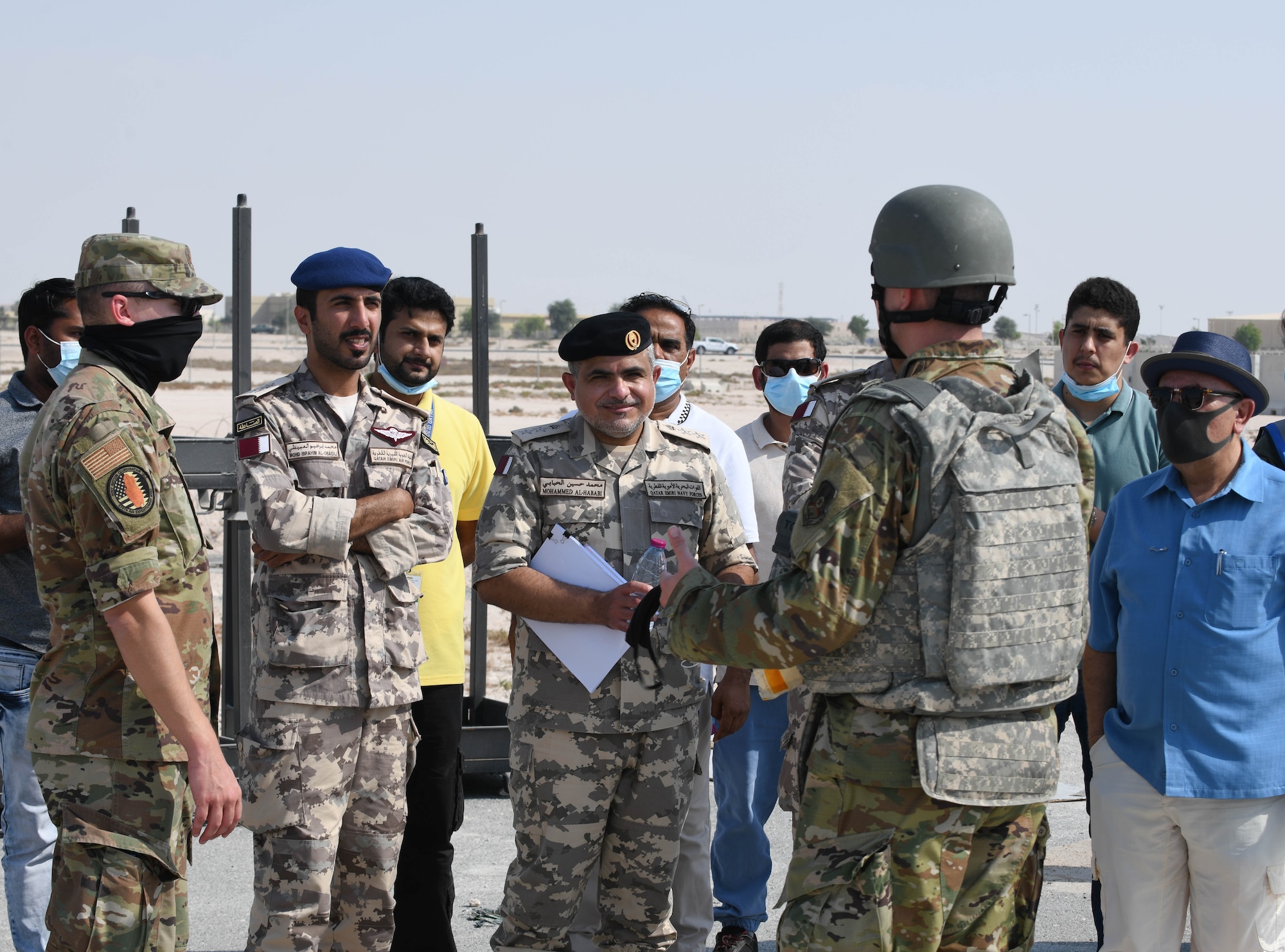 Qatar Emiri Air Force 1st Lt. Mohammed Ibrahim Al-Obaidli and Qatar Emiri Navy Forces Col. Mohammed Al-Hababi listen to U.S. Air Force Capt. Scott Guerin, with the 379th Expeditionary Civil Engineer Squadron, give a briefing at Al Udeid Air Base, Qatar, Nov. 18, 2020. Qatari civilians and military members observed the 379th ECES Airmen conduct rapid airfield damage repair training, which challenged them to efficiently and expeditiously restore a damaged airfield to operational status. (U.S. Air Force photo by Staff Sgt. Kayla White)