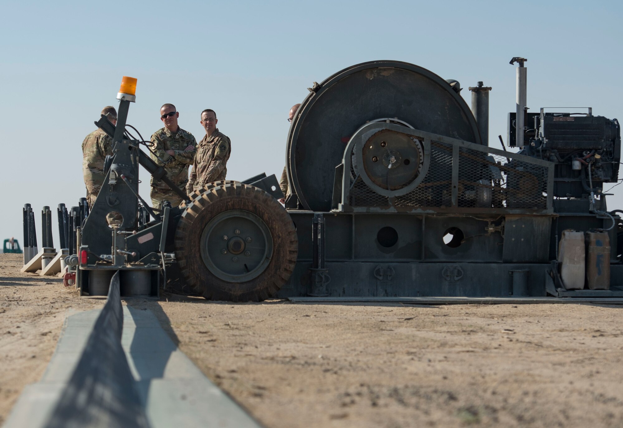 Members assigned to the 386th Expeditionary Civil Engineer Squadron electrical power production unit evaluate Mobile Aircraft Arresting System staging during a MAAS certification at Ali Al Salem Air Base, Kuwait, Nov. 22, 2020.