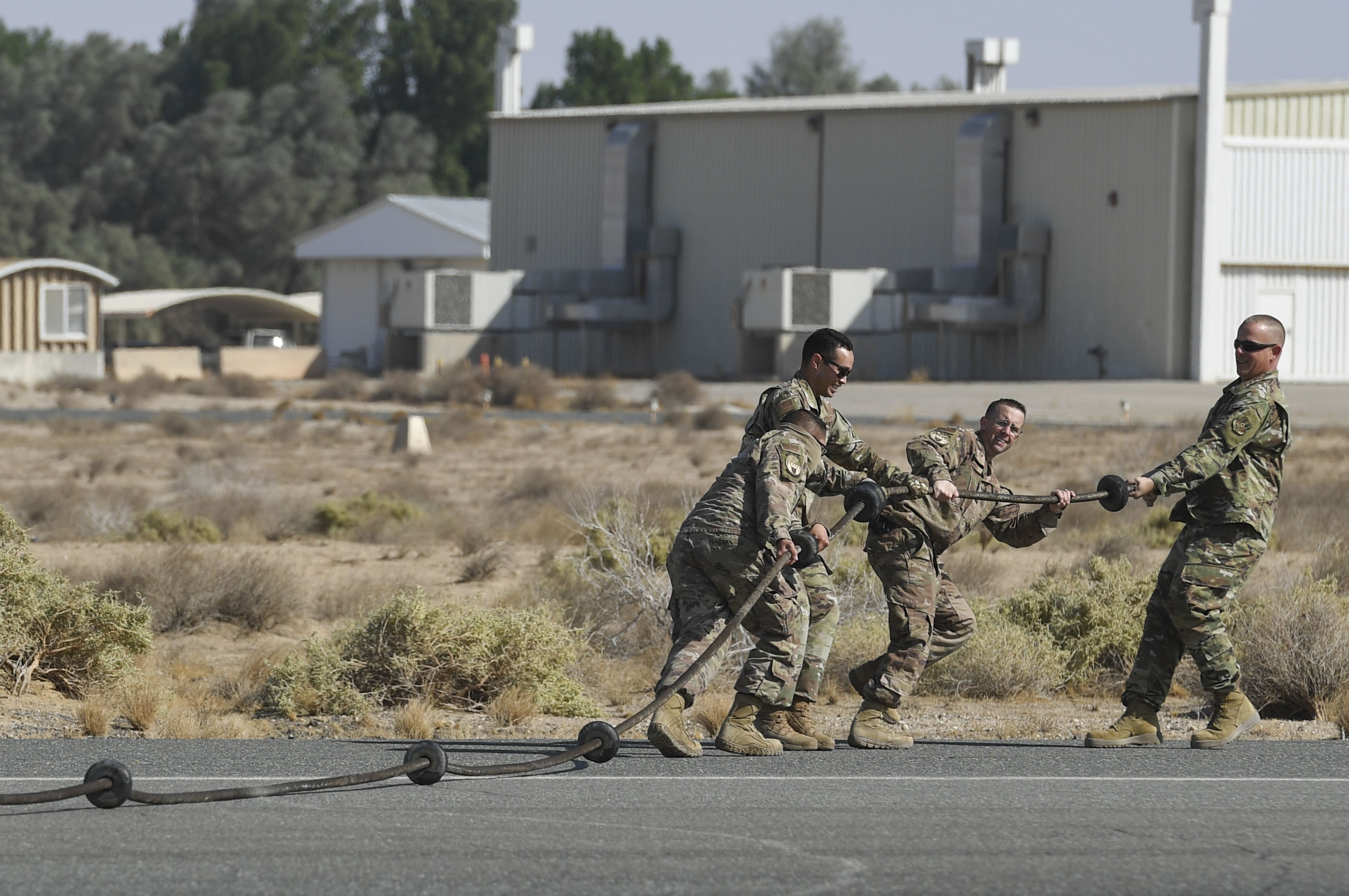 Members assigned to the 386th Expeditionary Civil Engineer Squadron electrical power production unit drag a Mobile Aircraft Arresting System cable off the runway during a MAAS certification at Ali Al Salem Air Base, Kuwait, Nov. 22, 2020.