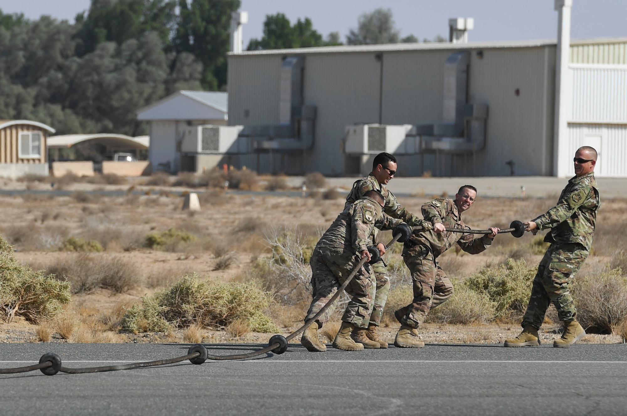 Members assigned to the 386th Expeditionary Civil Engineer Squadron electrical power production unit drag a Mobile Aircraft Arresting System cable off the runway during a MAAS certification at Ali Al Salem Air Base, Kuwait, Nov. 22, 2020.