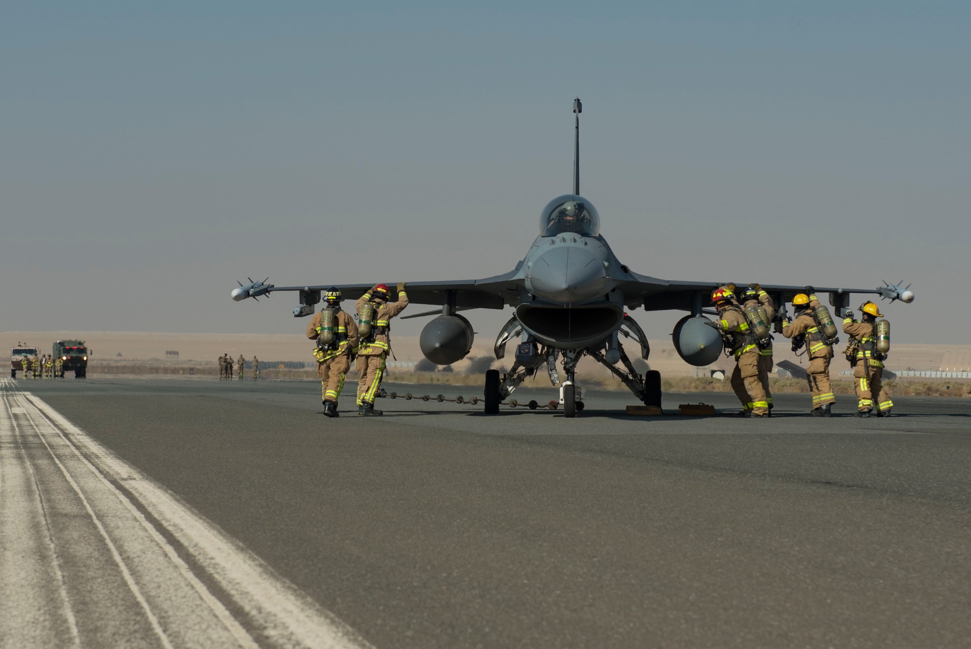 U.S. Air Force firefighters assigned to the 386th Expeditionary Civil Engineer Squadron push a 480th Expeditionary Fighter Squadron F-16 Fighting Falcon during a Mobile Aircraft Arresting System certification at Ali Al Salem Air Base, Kuwait, Nov. 22, 2020.