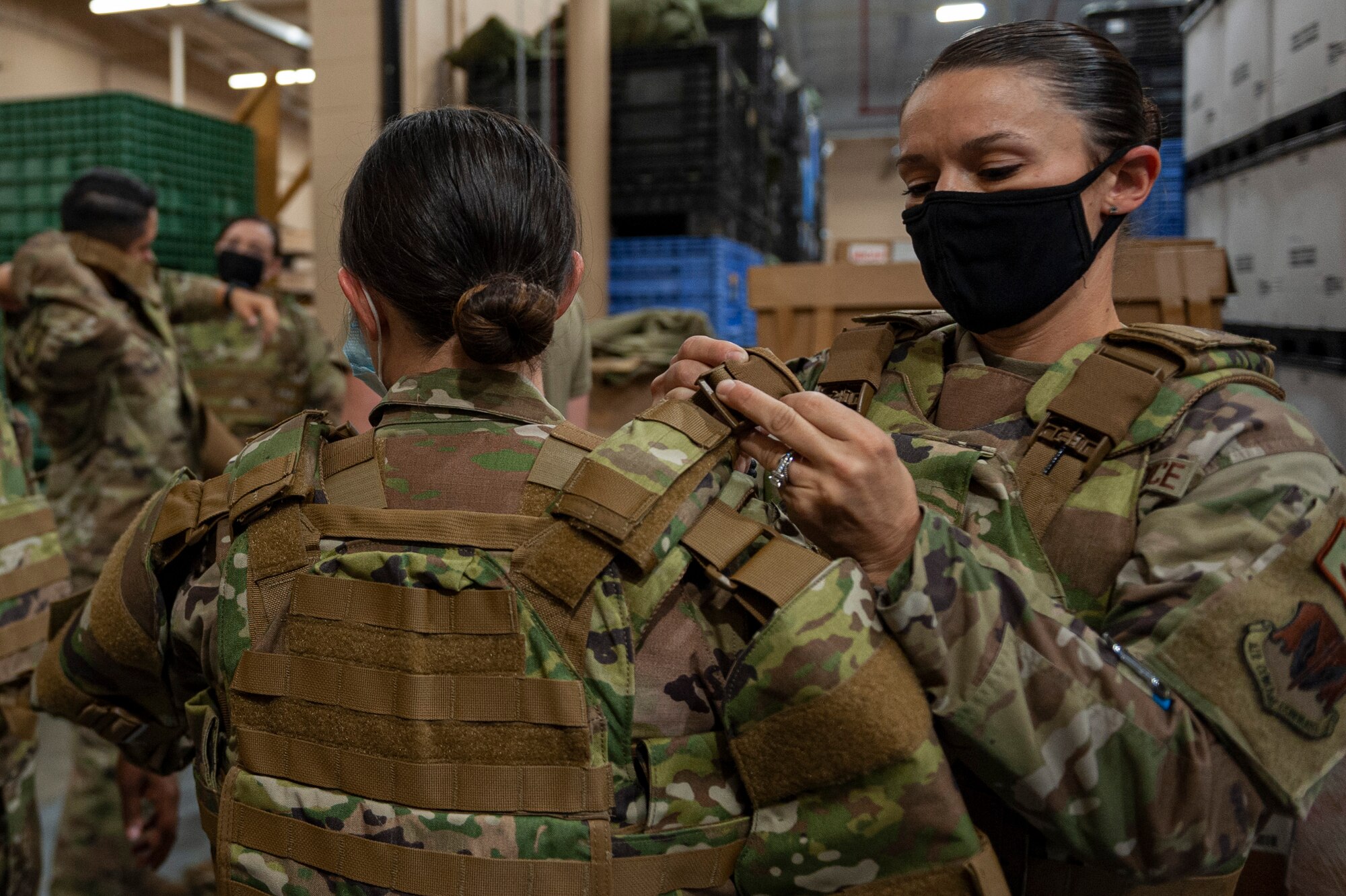 Photo of an Airman adjusting a vest strap