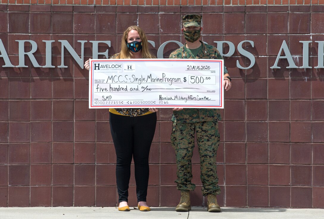 Jen Merlo, left, the Marine Corps Air Station (MCAS) Cherry Point Single Marine Program (SMP) coordinator, and U.S. Marine Corps Col. Mikel Huber, commanding officer of MCAS Cherry Point, accept a check donated by the Havelock Chamber of Commerce Military Affairs Committee Aug. 20, 2020. The Havelock Chamber of Commerce Military Affairs Committee donated funds to the SMP, the Disabled American Veterans charity, chapter 26, and the aeronautical technology program at Craven County Community College in lieu of hosting an annual membership event for installation leadership. (U.S. Marine Corps photo taken by Lance Cpl. Michael Neuenhoff)