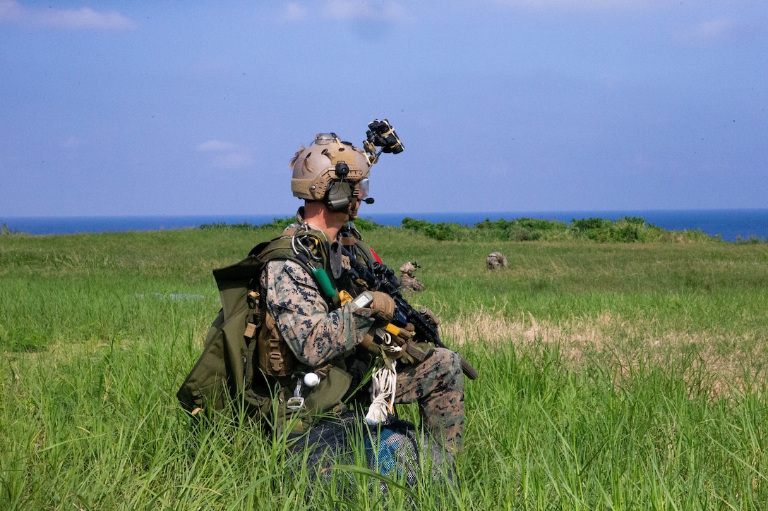 A U.S. Marine provides security after completing a high altitude-low opening jump to secure an airfield, facilitating a High Mobility Artillery Rocket System rapid infiltration and simulated firing mission at Ie Shima, Japan, Sept. 24.