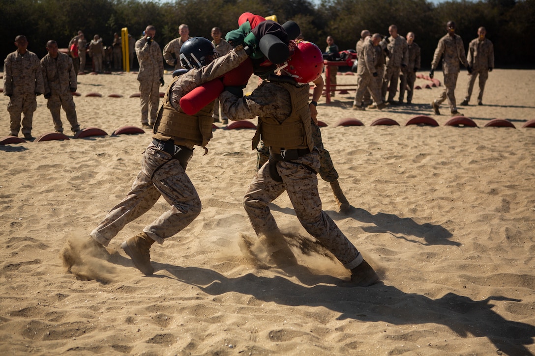 Two Marines use pugil sticks in a competition.