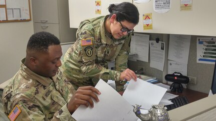 Pfc. Detron R. Mitchell, left, and Spc. Iris I. Claros, right, consolidate documents in the disbursing section of the Defense Military Pay Office for an inspection by the Network Audit Field Compliance Division of the Defense Finance and Accounting Service at Fort Campbell, Kentucky, Feb. 20, 2017. The U.S. Army Financial Management Command assumed the Army’s military pay mission from the Defense Finance and Accounting Service on Oct. 1, 2020.  (U.S. Army photo by 1st Lt. Todd A. Kuzma)
