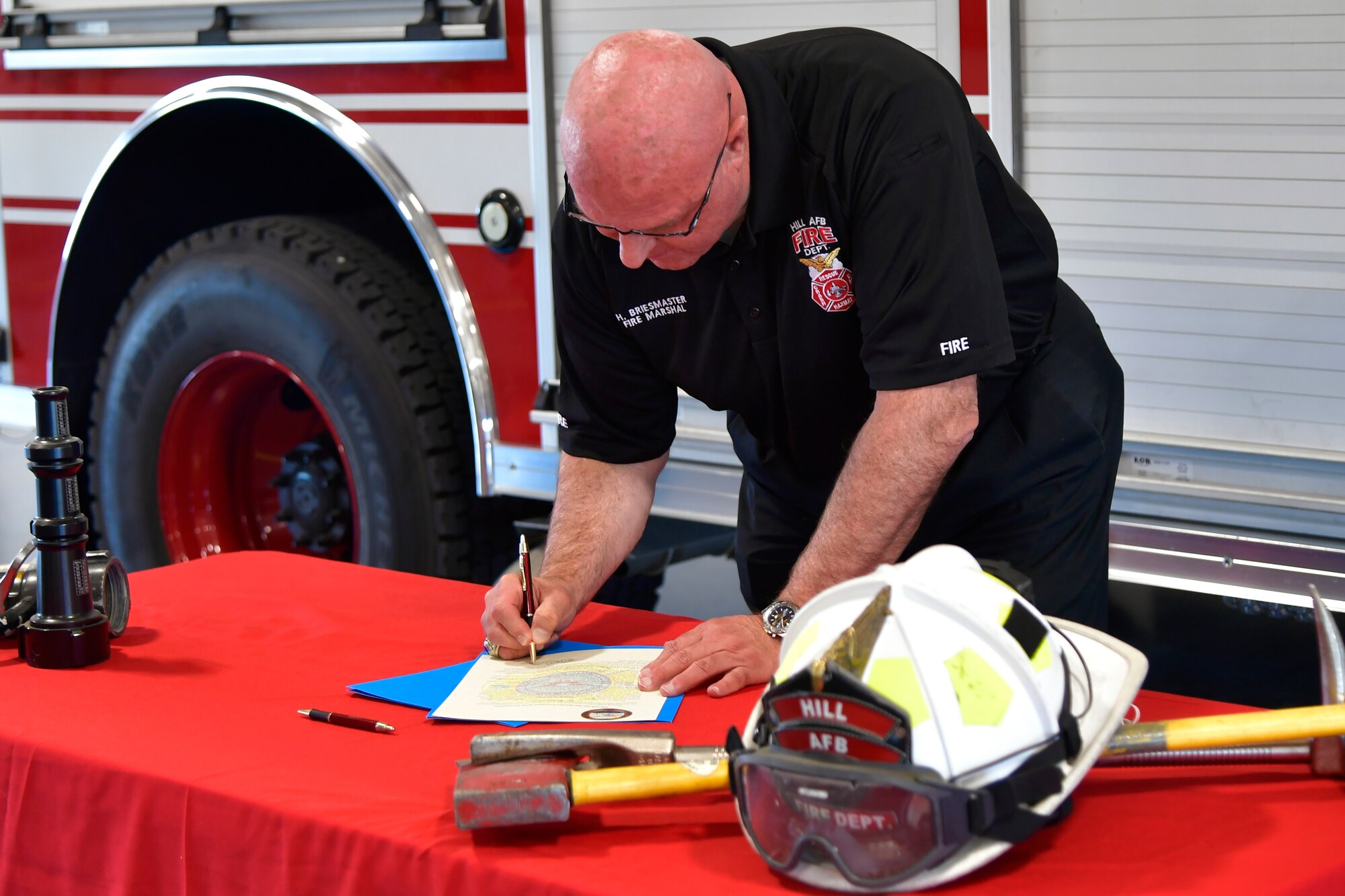 Harry Briesmaster, 75th Civil Engineer Group director and fire marshal, signs the proclamation during the signing ceremony.