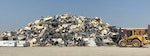 Material handlers gather scrap materials to prepare for removal operations to begin.