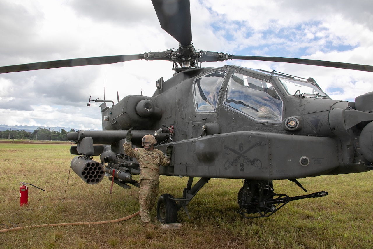 A soldier refuels a helicopter.