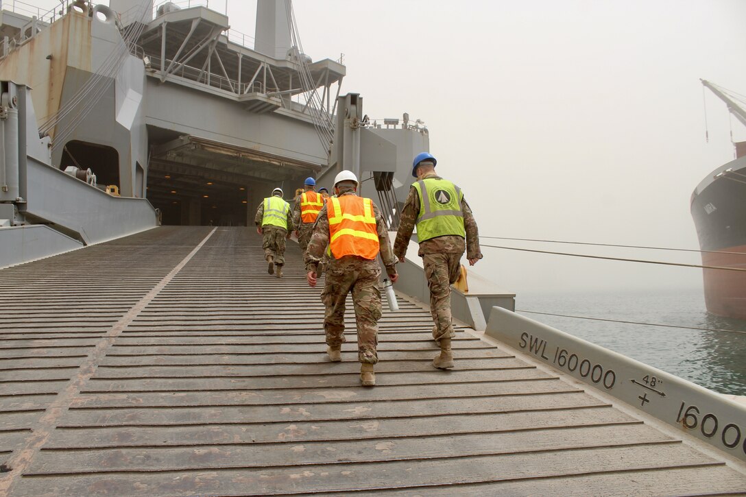 People walk up a ship's ramp.
