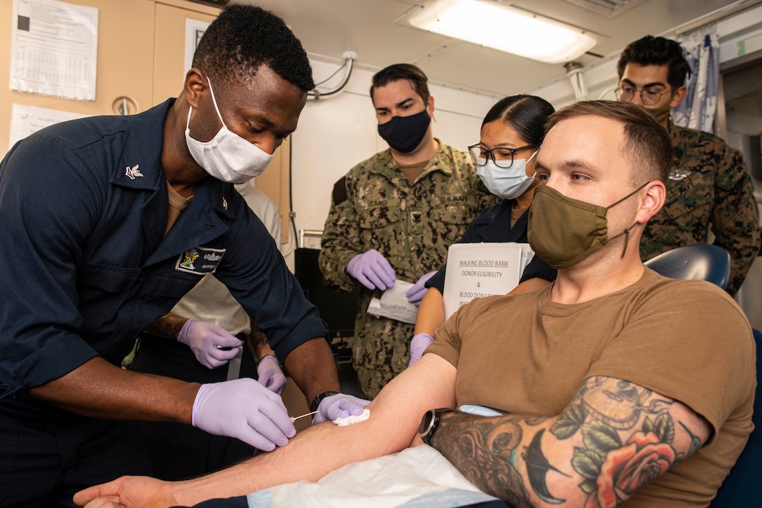 A sailor draws blood from another sailor.