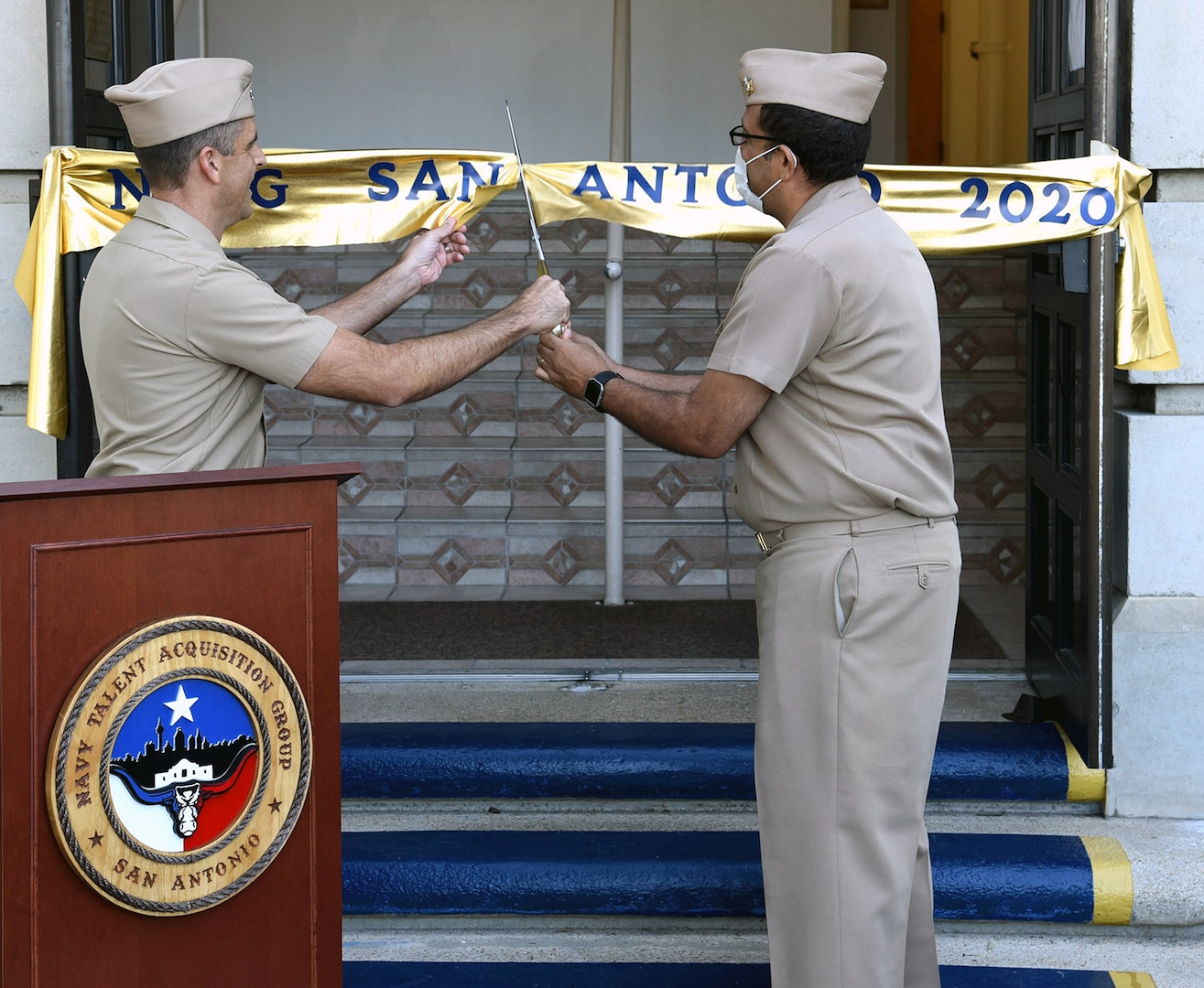 Cmdr. Nicholas Gamiz (left), commanding officer of Navy Talent Acquisition Group San Antonio, and executive officer Cmdr. Michael Files cut the ceremonial ribbon which decommissioned Navy Recruiting District San Antonio and established NTAG San Antonio at NTAG headquarters.