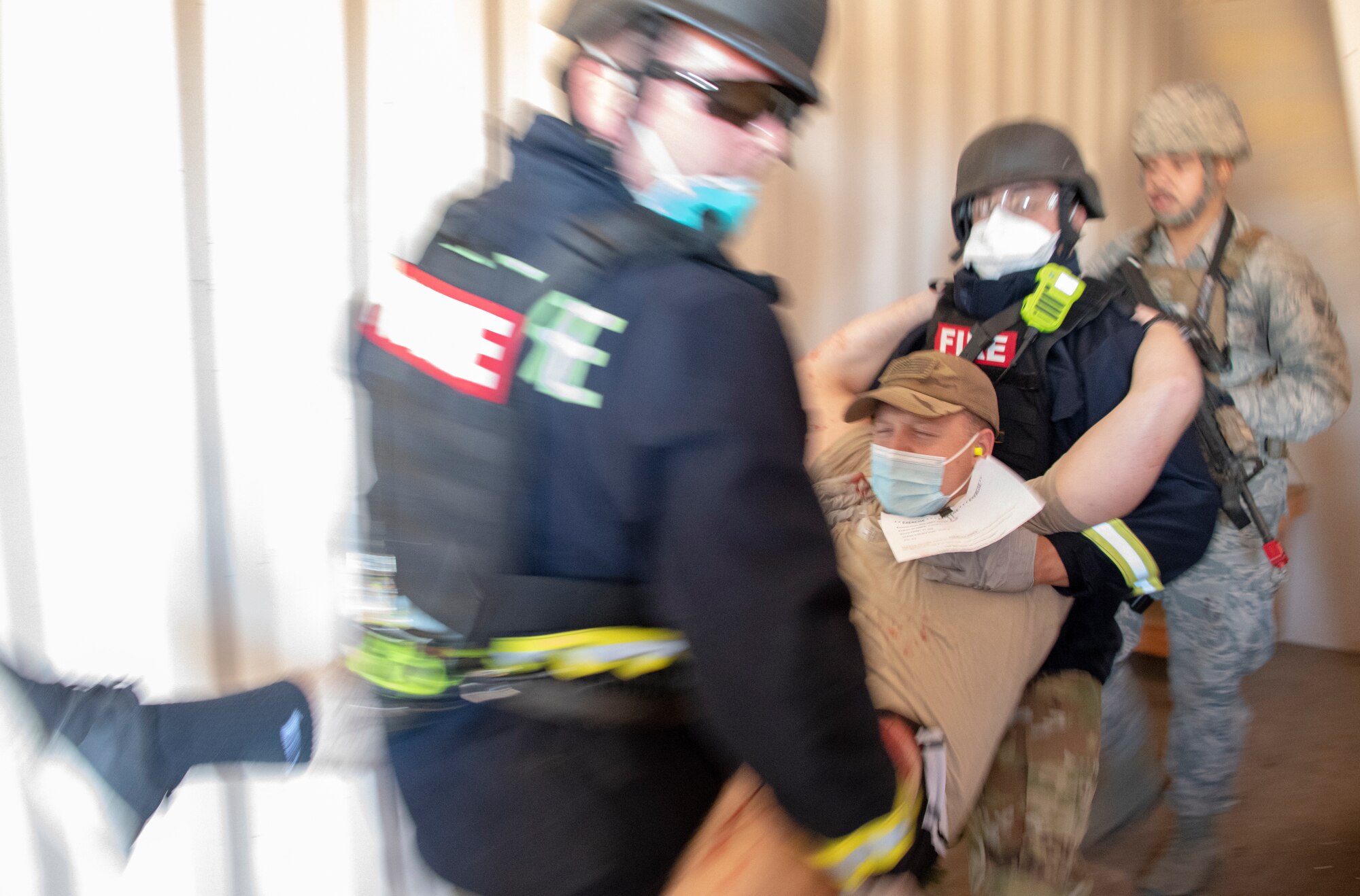 First responders carry a simulated victim out of a building during a base exercise Sept. 24, 2020, at Travis Air Force Base, California. The exercise was designed to evaluate the training, readiness and capability of Travis first responders in order to effectively respond to active shooter threats to the installation. (U.S. Air Force photo by Heide Couch)