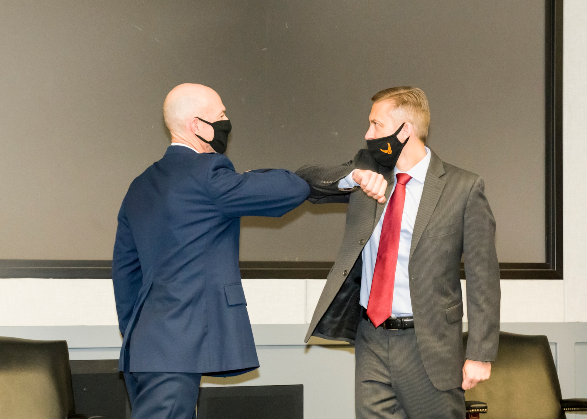 Air Force Test Center Commander, Maj. Gen. Christopher Azzano, congratulates Christopher Klug, the new Multi-Domain Test Force Detachment 1 director.