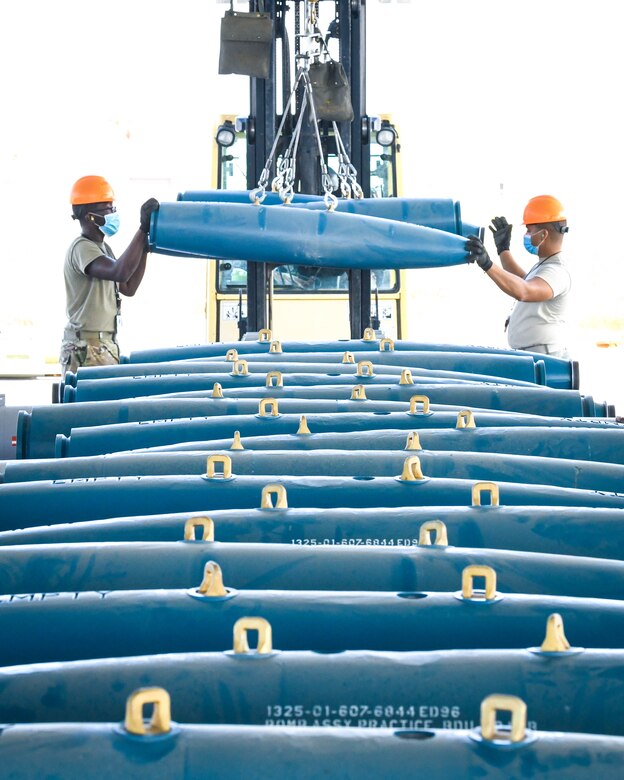 Airman Quinton Chaney, 56th Equipment Maintenance Squadron munitions systems technician, and Senior Airman Tre Tate, 56th EMS munitions systems technician, use a forklift sling to move GBU-12 Paveway II laser-guided bombs Sept. 22, 2020, at Luke Air Force Base, Arizona.