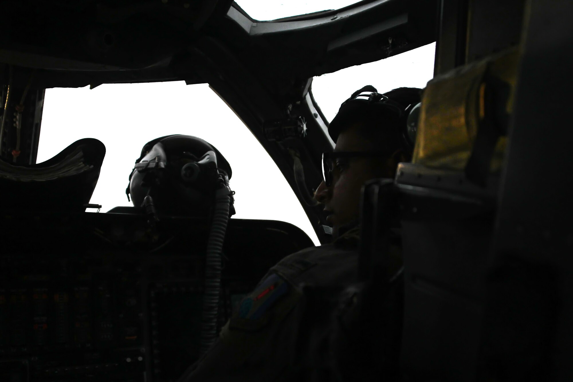 Photo of B-1 pilot performing pre-flight checks in cockpit.