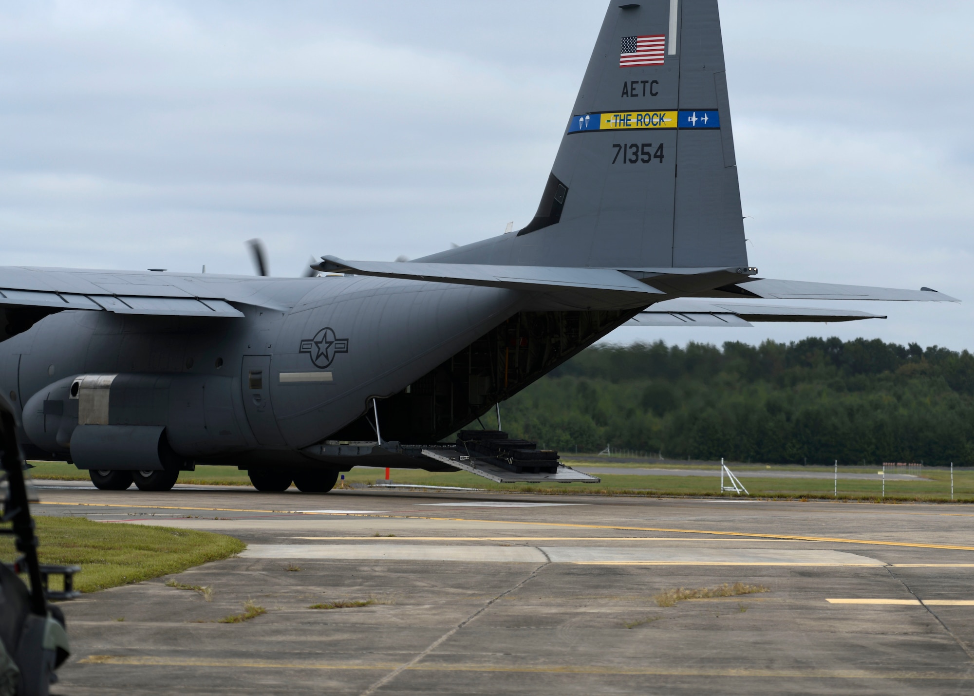 A C-130 drives down the flightline and prepares to drop off a pallet.