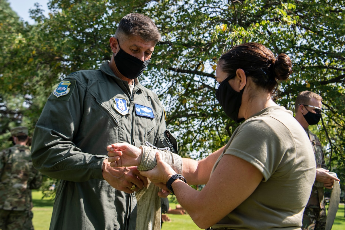 Col. Glen Collins, 932nd Airlift Wing commander, practices self-aid and buddy care on Chief Master Sgt. Barbara Gilmore, 932nd AW command chief, during Operation Centennial Summit, Peterson Air Force Base, Colorado, Sept. 15, 2020. Operation Centennial Summit gave members the opportunity to get hands-on training such as litter carry procedures, triage, self-aid and buddy care, respiratory distress and numerous lectures on other medical emergencies. The 932nd AW is a reserve unit at Scott Air Force Base, Illinois. (U.S. Air Force photo by Senior Airman Brooke Spenner)