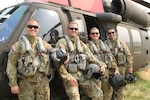 Members of 1st Battalion (Assault), 147th Aviation Regiment, 64th Troop Command, Wisconsin Army National Guard, at the Exeter helicopter bases Sept. 30, 2020, before a mission during the SQF Complex Fire in Tulare County, California. Left to right: Sgt. Jake Baranczyk, crew chief; Chief Warrant Officer 2 Trevor Clock, pilot; Sgt. Bryson Kamps, crew chief; and Chief Warrant Officer 3 Andrew Wickland, pilot in command.